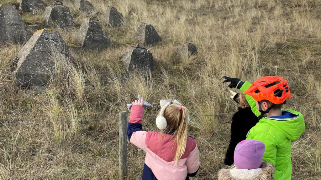 De kinderen kijken richting de duinen op zoek naar de volgende aanwijzing van Puzzelen op de Pedalen.