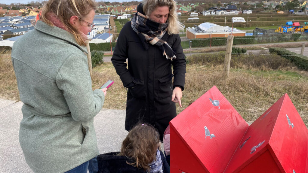 Twee dames kijken toe hoe iemand een slot probeert te openen van de fietskar.