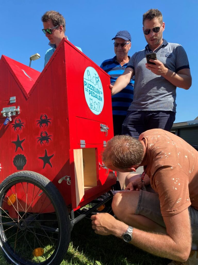 Een man kijkt in het vakje van de puzzelkar.