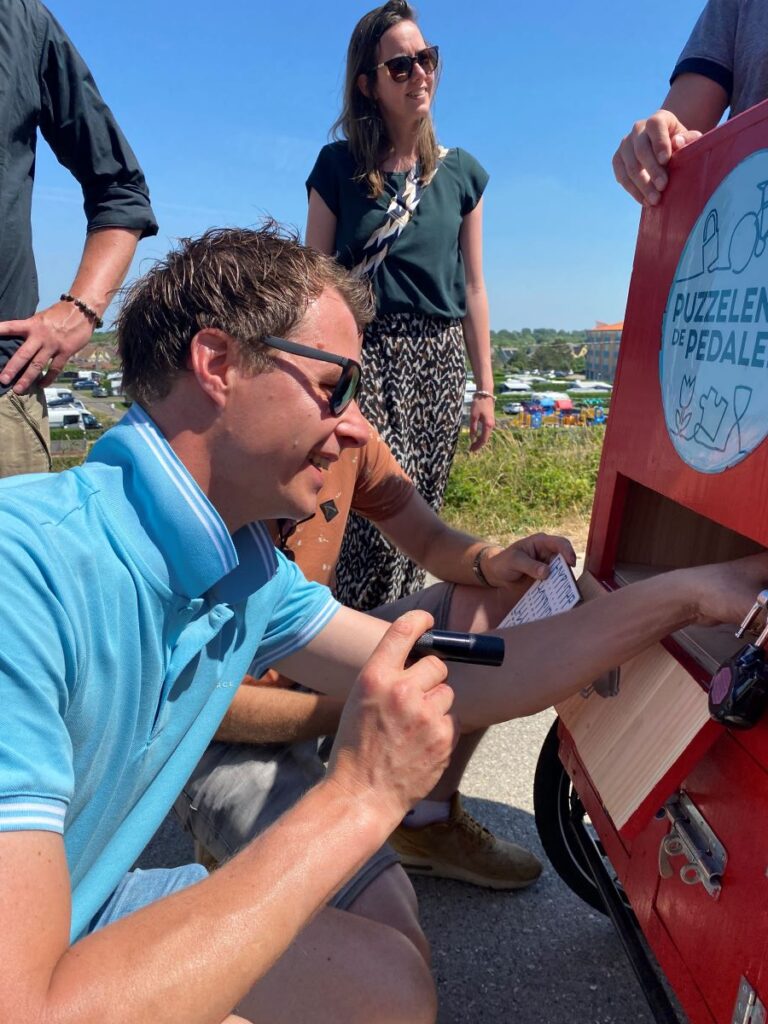 Een man schijnt met een zaklamp in het vakje van de puzzelkar.