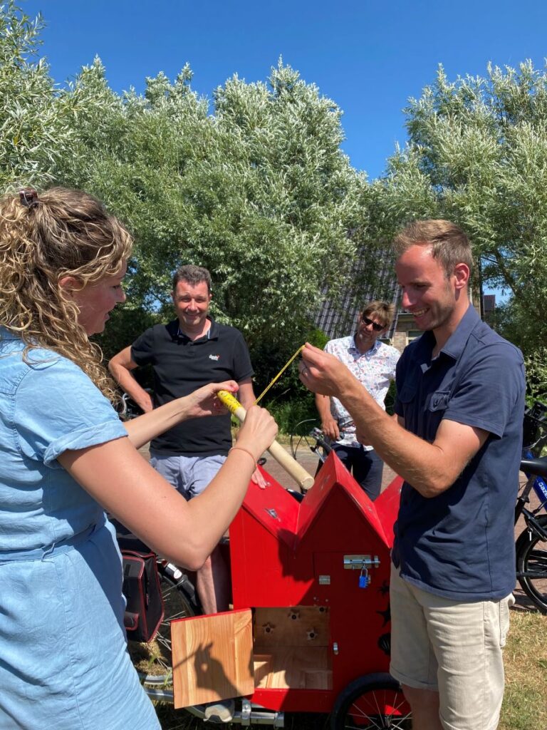Een man en een vrouw houden samen een stok vast met een aanwijzing van de puzzel.