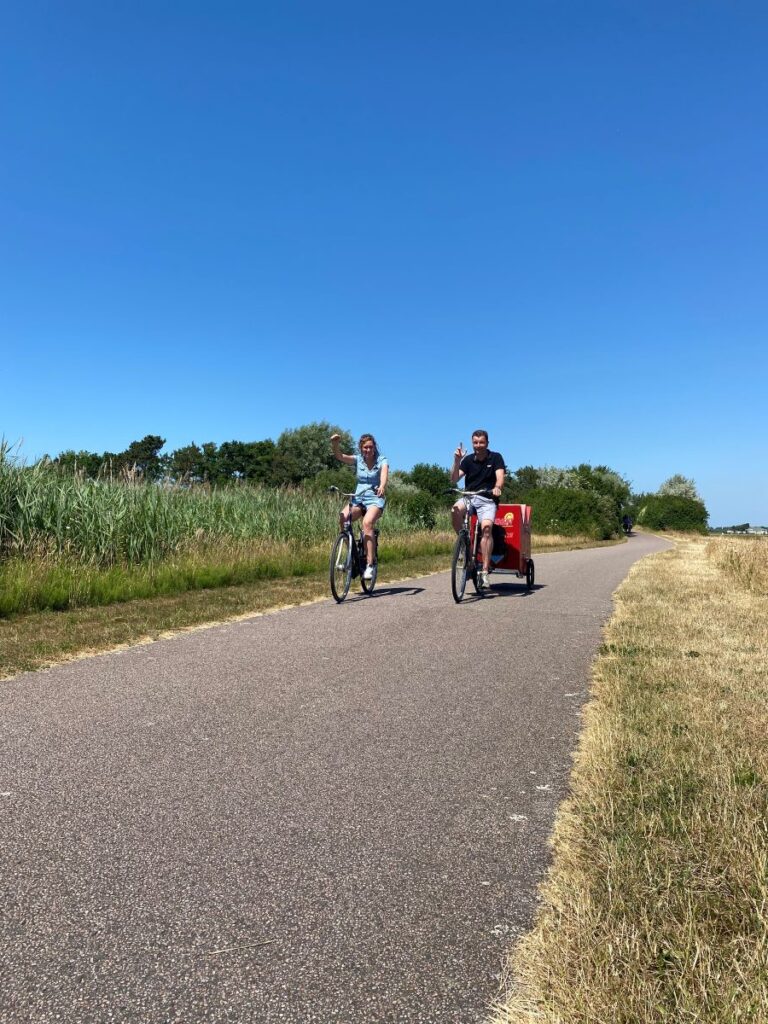 Twee personen komen aangefietst met de puzzelkar.
